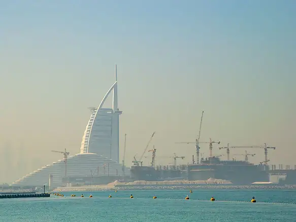 Panorama Dubaje se stavebními jeřáby a hotelem Burj Al Arab v pozadí
