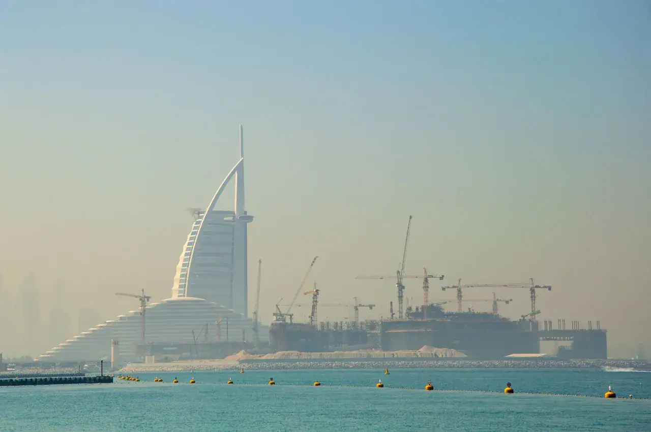 Panorama Dubaje se stavebními jeřáby a hotelem Burj Al Arab v pozadí