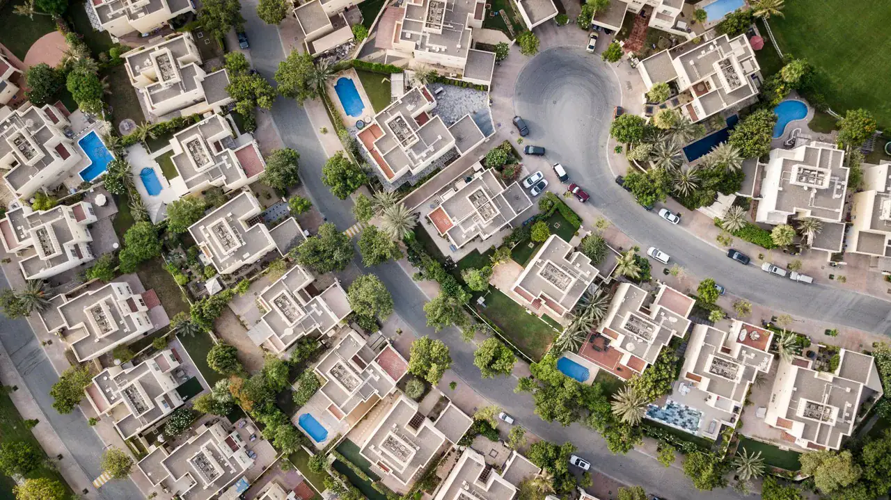 Letecký pohled na dubajskou vilovou čtvrť s bazény a zahradami