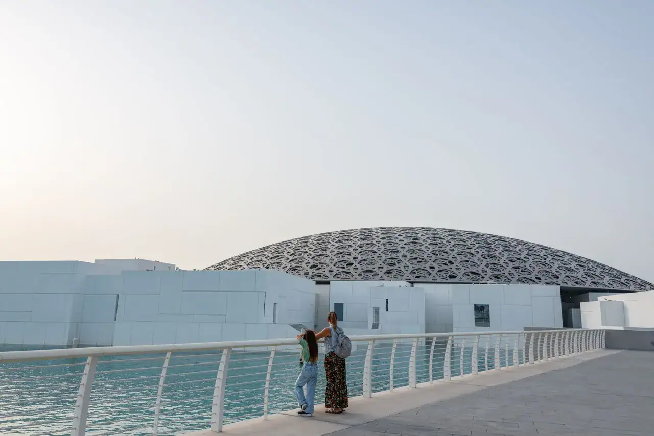 Matka s dcerou na molu u Louvre Abu Dhabi na Saadiyat Island, v pozadí děrovaná kupole