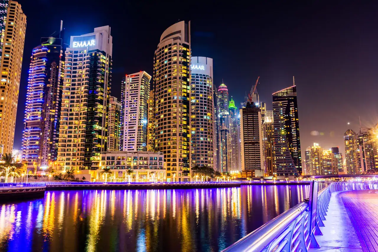 Noční Dubai Marina s osvětlenými obytnými věžemi a promenádou u vody